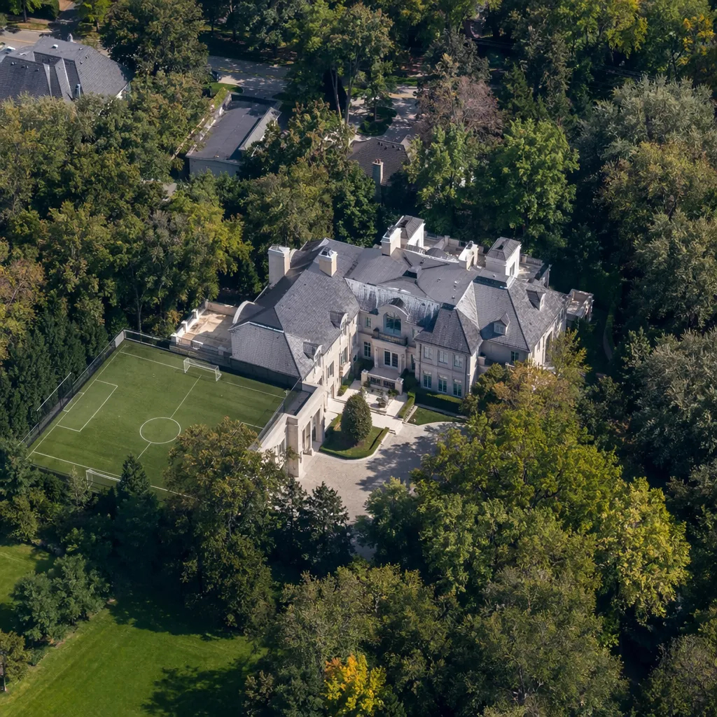 Aerial view of a large private manor with a small attached football field in sub