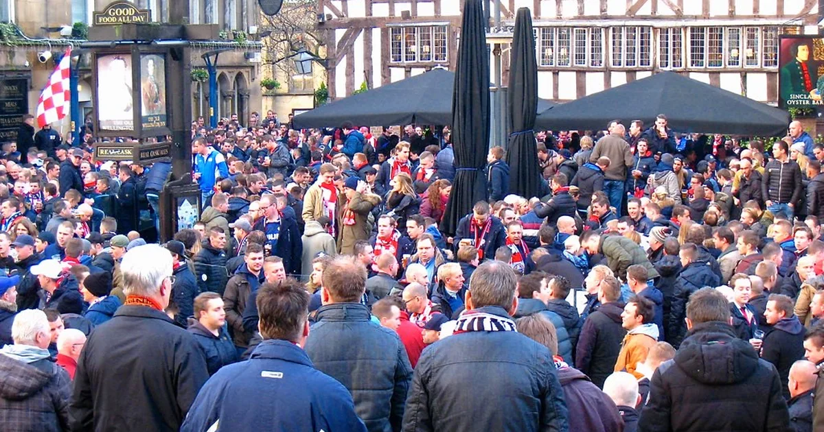 Football fans debating in a sports forum, blurred background of a Premier League stadium,