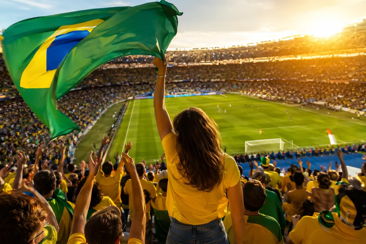 Wide shot of a packed football stadium during World Cup match, excited female leader figur