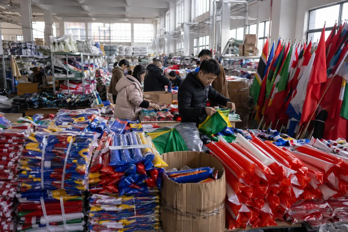 A busy warehouse in Yiwu, China, with stacks of colorful unbranded football fan merchandis